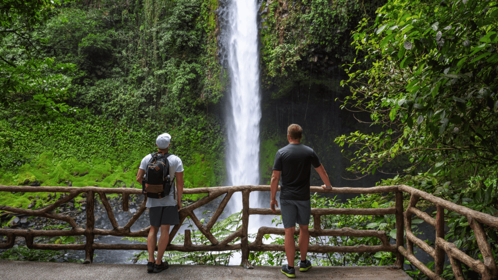 13bc2081 7f44 4715 ac25 99c6cb84f7dc Two tourists looking at the La Fortuna Waterfall in Costa Rica