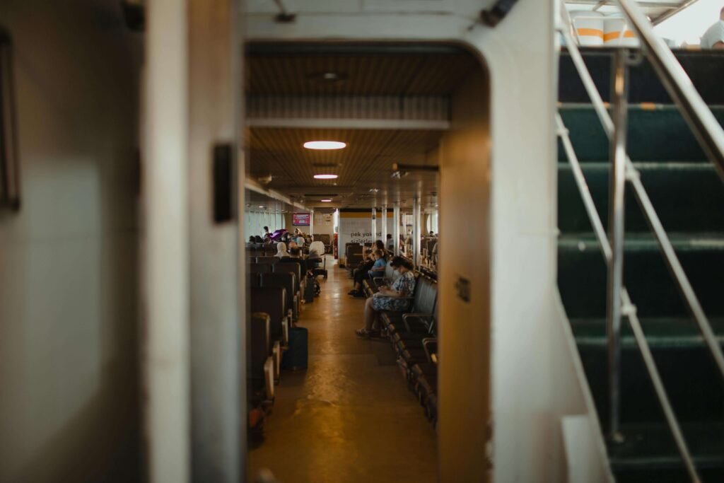 Interior passenger cabin of the Puntarenas to Paquera car ferry in Costa Rica, with rows of seats and travelers resting during the crossing
