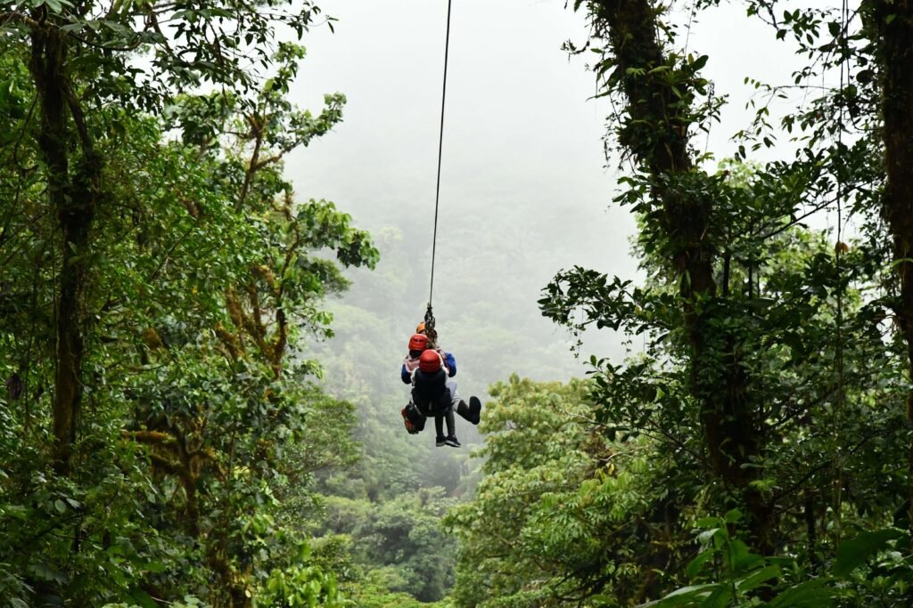 Two people ziplining tandem through the rainforest canopy on a Costa Rica canopy tour