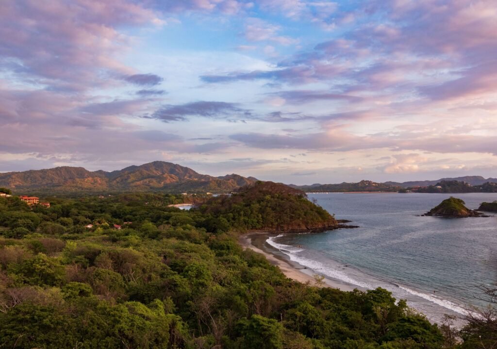 Sunset over a sheltered cove and forested hills along the Gulf of Papagayo, similar to Playa Iguanita, Costa Rica