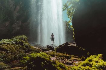 Jungle waterfall spilling into a calm green pool surrounded by rainforest, similar to Catarata Uvita, Costa Rica